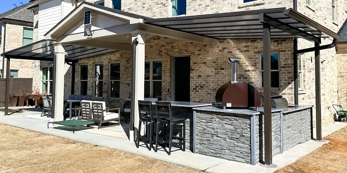 stone outdoor kitchen with pizza oven on extended patio