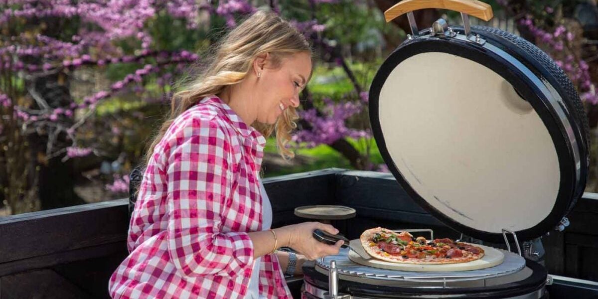tamara day cooking a pizza on a coyote asado smoker