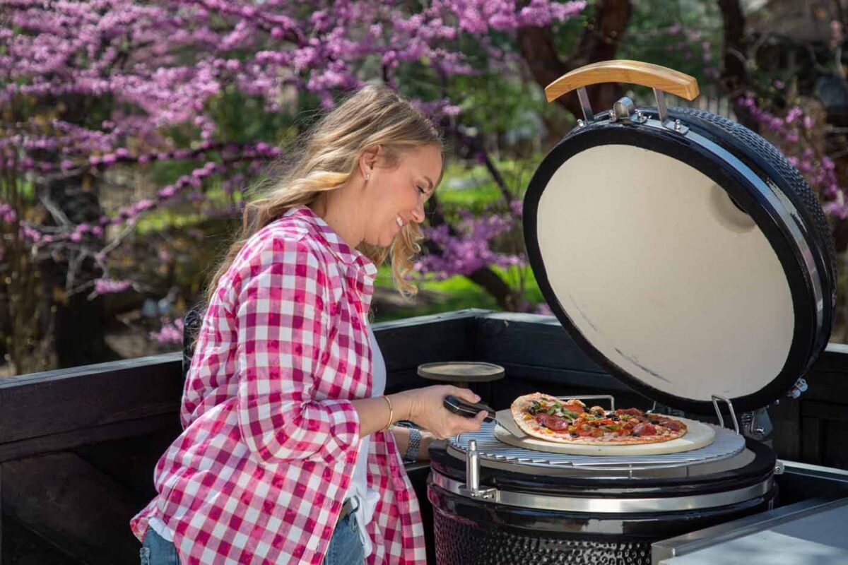 tamara day cooking a pizza on a coyote asado smoker