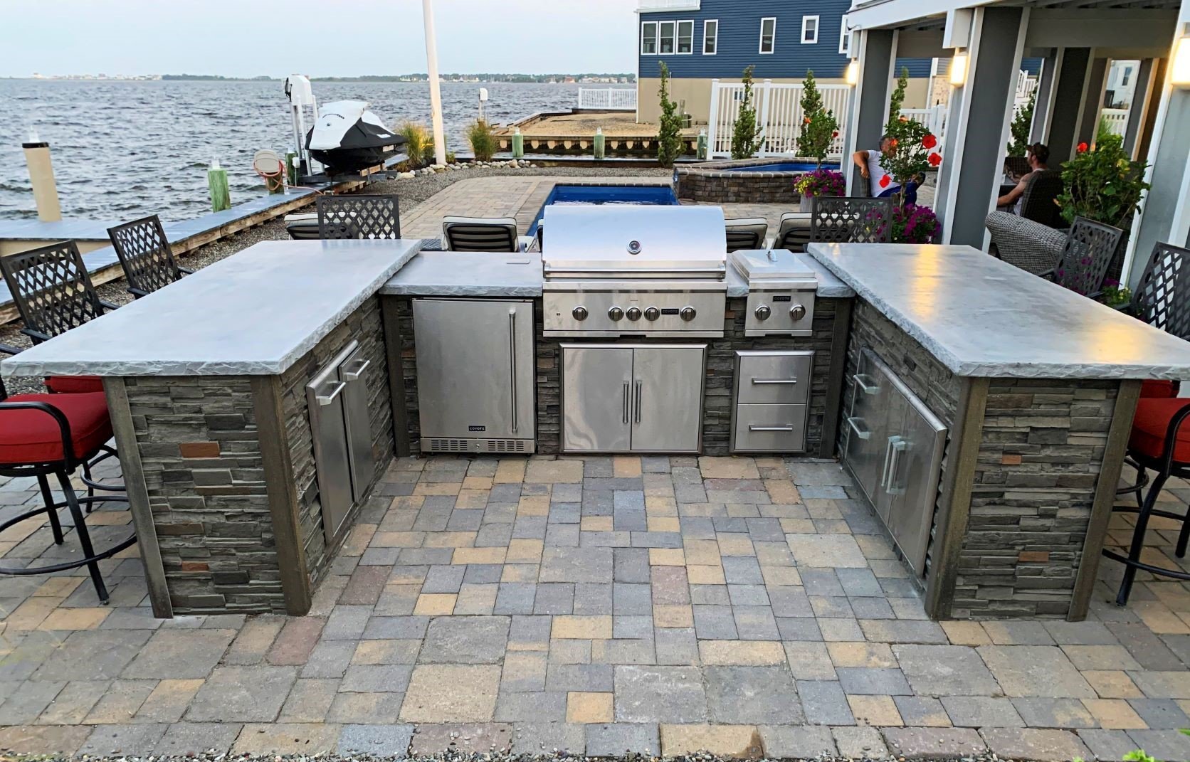 top of the line custom u-shape outdoor kitchen with stainless steel appliances by water