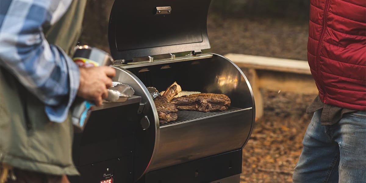 two guys grilling with best small pellet smoker