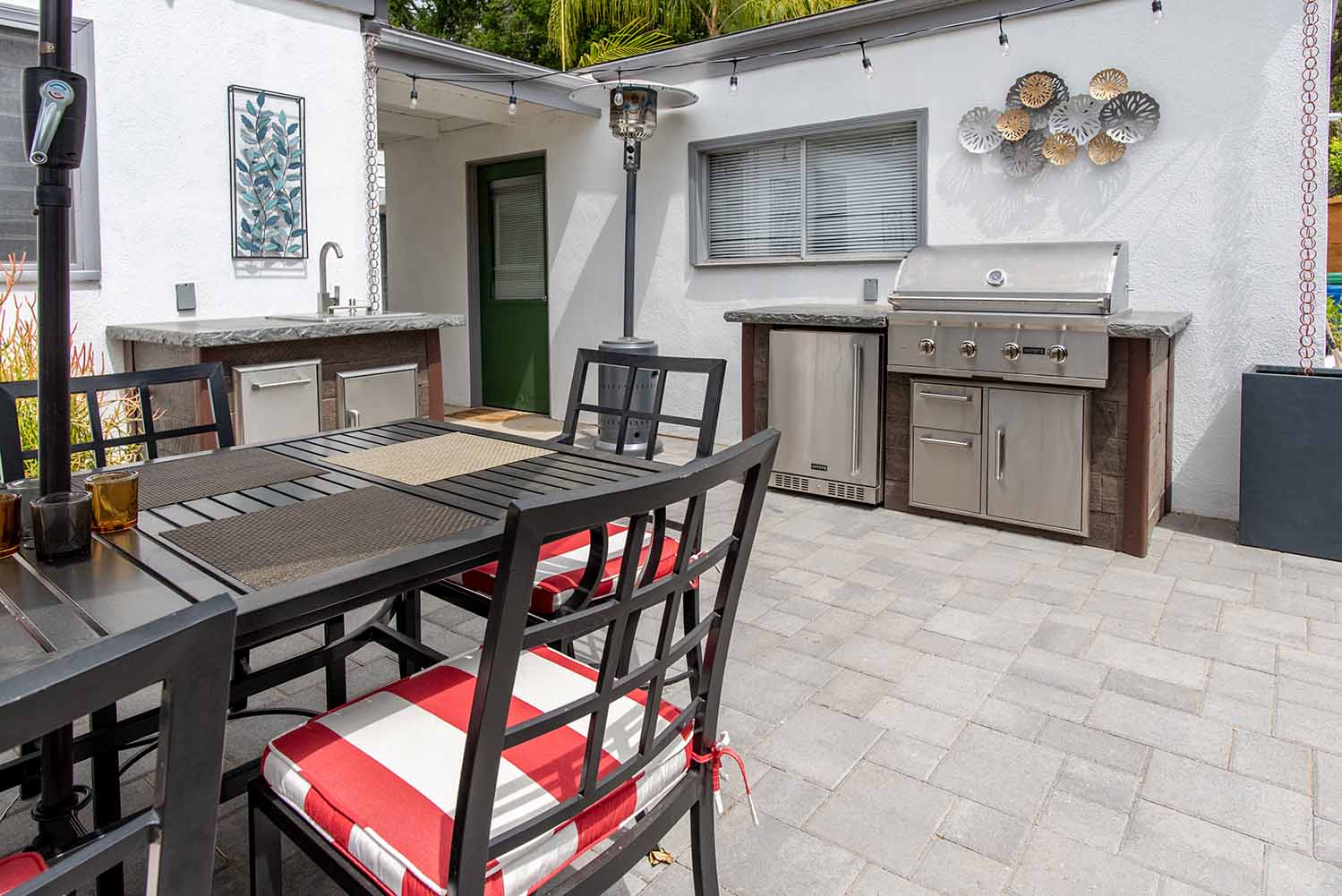 two small outdoor kitchen islands in separate locations with sink fridge and grill creating the perfect design idea