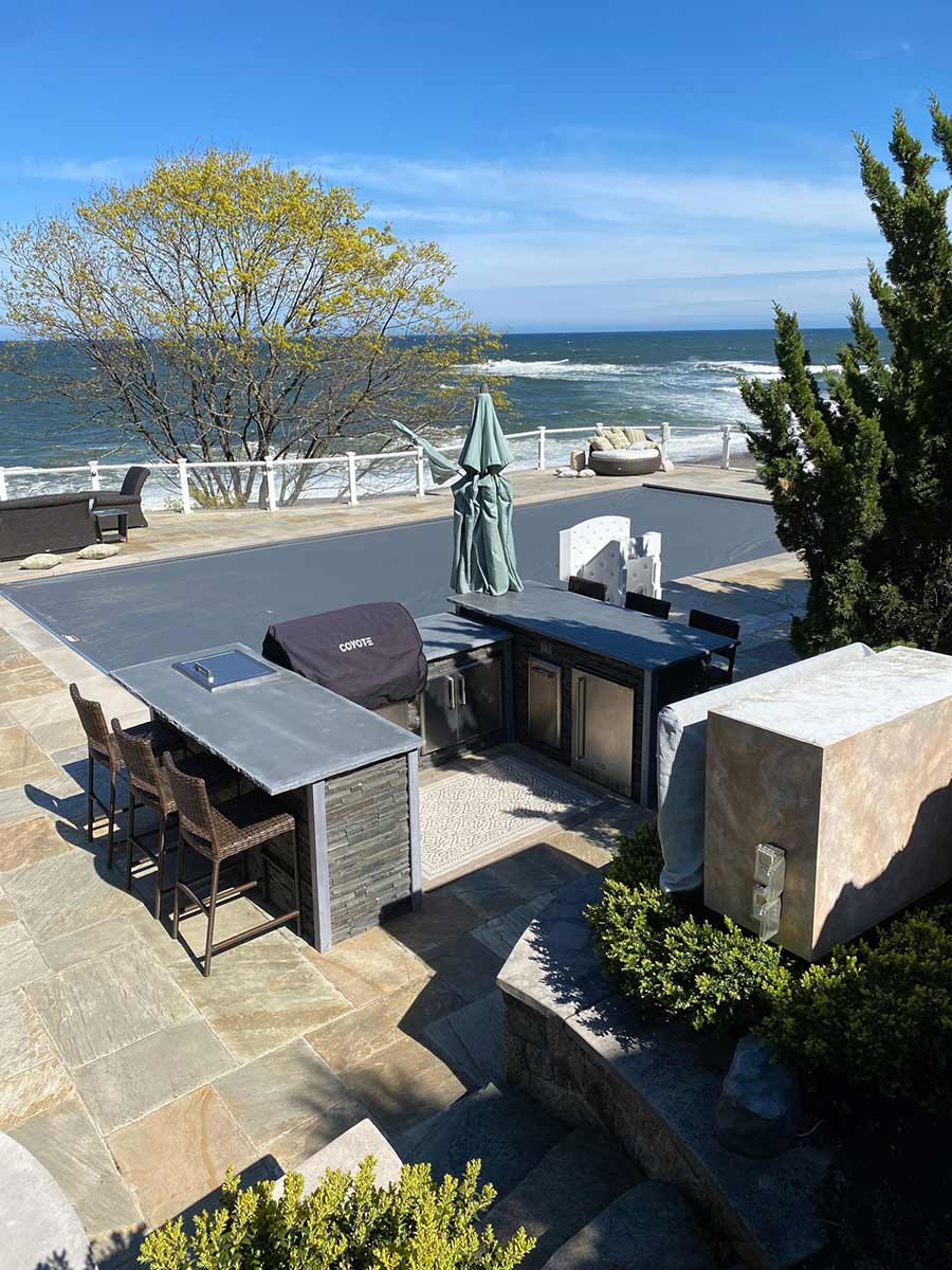 u shaped outdoor kitchen by covered pool near the ocean