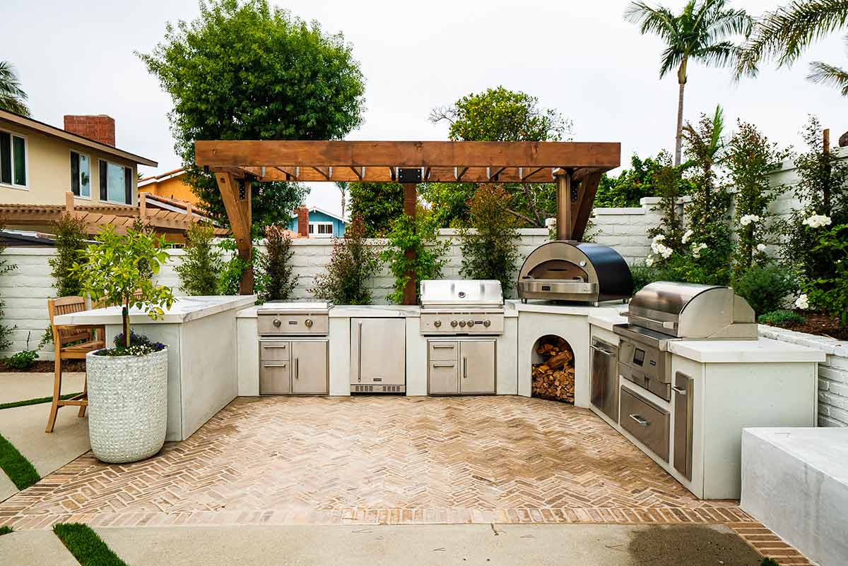 u shaped outdoor kitchen under pergola with pizza oven and pellet grill