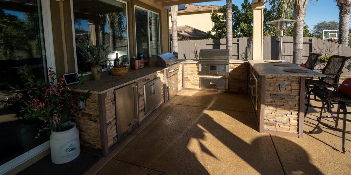 u shaped stacked stone outdoor kitchen on patio
