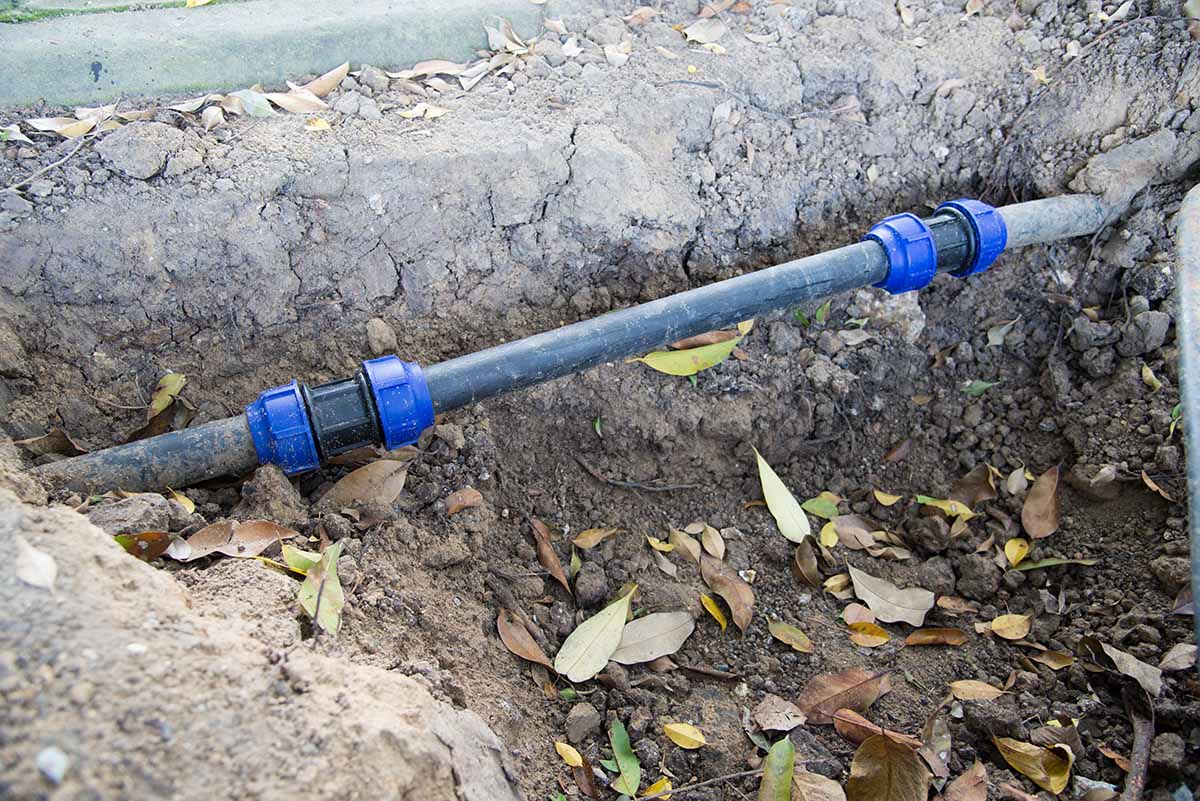utility line in ground to supply outdoor kitchen by connecting to a drain line