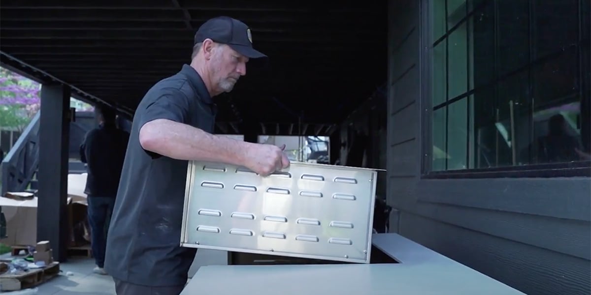 Ward Schraeder installing a grill jacket into a MOKS outdoor kitchen