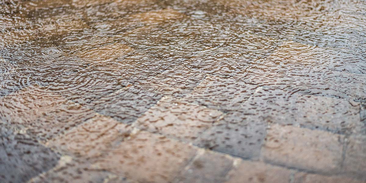 water gathering on a paver patio due to poor drainage