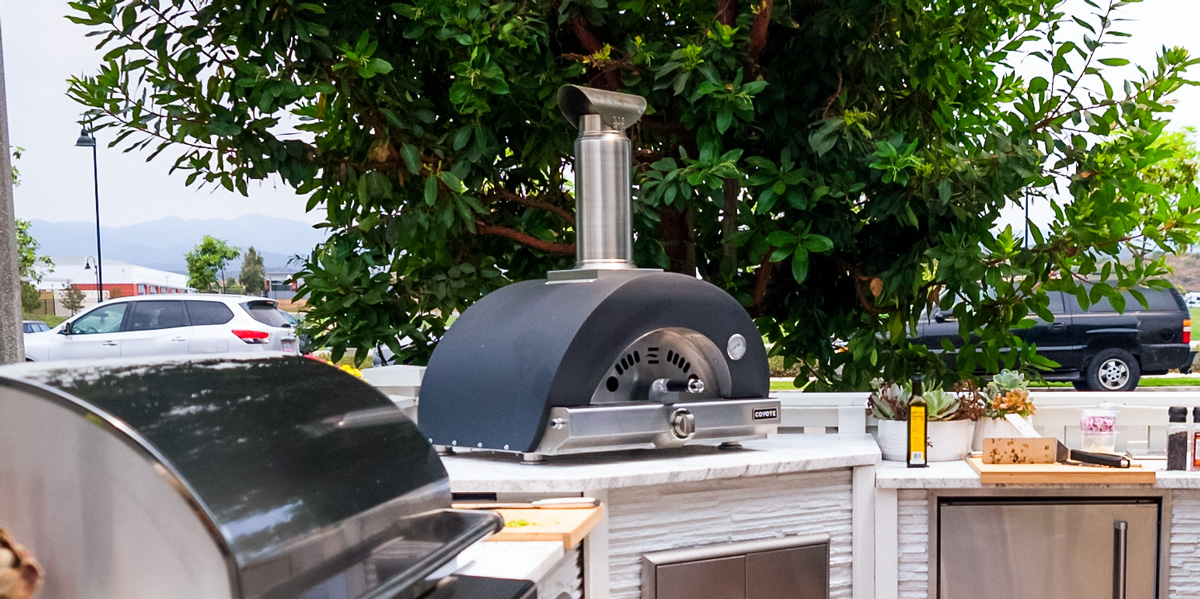 wood fired outdoor pizza oven on outdoor kitchen countertop