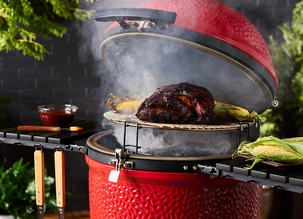 red kamado joe ceramic smoker with meat cooking